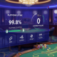 Sleek live online casino interface with uptime and payout success indicators, secure padlock icon, and abstract regulatory certification symbols, set against a luxurious, empty live casino studio backdrop, representing a decade of reliable operation.